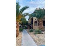 Tan two-story apartment building featuring a walkway and palm tree landscaping at 3135 S Mojave Rd # 113, Las Vegas, NV 89121