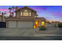 Charming two-story home featuring a three-car garage and desert landscaping at sunset at 353 Templeton Dr, Henderson, NV 89074