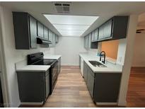 Updated kitchen features gray cabinets, quartz countertops and modern appliances at 3585 Arville St # 403A, Las Vegas, NV 89103