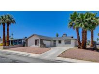 Single-story home featuring a gravel yard, palm trees, and a driveway leading to an attached garage at 4484 Bennett Dr, Las Vegas, NV 89121