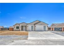 Charming single-story home with a three-car garage and minimalist desert landscaping at 4781 Stoneham, Pahrump, NV 89061