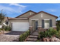Charming single-story home featuring a two-car garage, stone accents, and desert landscaping at 737 Wild Highlands Ln, Henderson, NV 89015