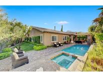Beautiful backyard pool and spa area with covered patio and elegant landscaping, perfect for outdoor entertaining at 748 Puerto Real Ct, Las Vegas, NV 89138