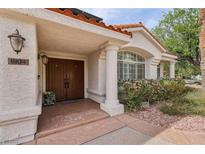 Inviting front entrance with double doors, decorative columns, and a well-manicured garden at 8104 Wispy Sage Way, Las Vegas, NV 89149