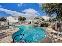 Resort-style pool with rock waterfall feature, lounge chairs, and nearby cabana for relaxing on a sunny day at 10360 Cherry Brook St, Las Vegas, NV 89183