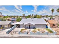 Charming single story home with desert landscaping, white paint and grey trim, palm trees, and mountain views at 1112 Sandy Cove St, Las Vegas, NV 89110