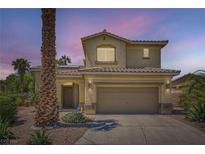 Inviting two-story home featuring a well-manicured lawn, desert landscaping, and attached two-car garage at 1701 Drifters Peak St, Las Vegas, NV 89144