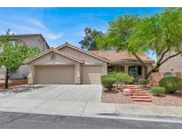 Charming single-story home featuring a two-car garage, desert landscaping, and a tile roof at 209 Prairie Creek St, Henderson, NV 89012