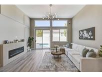 Bright living room with fireplace, stylish lighting, and sliding glass doors to the pool at 2714 Langlade Ave, Henderson, NV 89052
