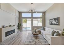 Bright living room features modern fireplace, recessed lighting, and sliding glass doors to backyard pool at 2714 Langlade Ave, Henderson, NV 89052