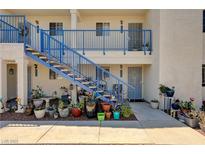 Apartment complex with bright blue staircase and patio featuring a multitude of various potted plants at 2725 S Nellis Blvd # 1038, Las Vegas, NV 89121