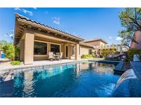Backyard pool with waterfall feature, covered patio and seating area at 2896 Grande Arch St, Henderson, NV 89044