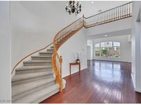 Stunning entryway with a curved staircase, wood floors, and a decorative chandelier at 3728 White Lion Ln, North Las Vegas, NV 89084