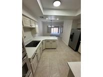 Bright kitchen with white cabinets, countertops and tile flooring, stainless steel appliances, and an open layout at 5316 Fieldstone Rd, Las Vegas, NV 89107