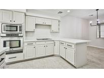 Bright kitchen features white cabinets, modern appliances, and quartz countertops at 5316 Fieldstone Rd, Las Vegas, NV 89107