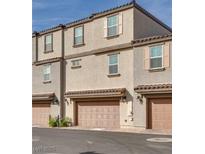 Three-story townhome with two car garage and neutral stucco, roof and doors at 538 Ylang Pl, Henderson, NV 89015