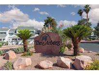 Stone entrance sign to The Arbors community with well-maintained landscaping and palm trees under a partly cloudy sky at 5523 Orchard Ln # 0, Las Vegas, NV 89110