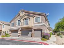 Inviting townhouse featuring a private balcony and attached two-car garage, all set against a bright blue sky at 5552 Dueces Wild Ct # 101, Las Vegas, NV 89122