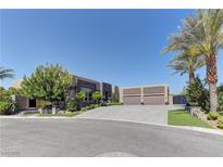 Beautiful single story home with a three car garage, lush landscaping, and a paver driveway at 6845 Hidden Sunset Ln, Las Vegas, NV 89120