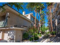 Charming condo exterior featuring well-maintained landscaping and a private garage in a vibrant community at 7143 S Durango Dr # 202, Las Vegas, NV 89113