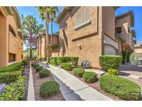 Charming townhome exterior featuring a well-maintained walkway and lush landscaping at 8737 Red Brook Dr # 204, Las Vegas, NV 89128
