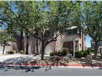Charming townhome with a two-car garage and covered entryway, surrounded by lush greenery at 9116 Vista Greens Way # 104, Las Vegas, NV 89134