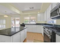 Bright kitchen with white cabinets, granite countertops and stainless steel appliances at 9746 Driftwood Island Ct, Las Vegas, NV 89148
