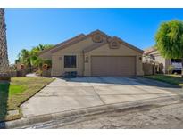 Charming single-story home with desert landscaping, a spacious driveway, and a two-car garage at 1441 Palm Dr, Laughlin, NV 89029