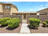 Charming front entrance featuring desert landscaping, a decorative gate, and a well-maintained walkway at 2204 Short Pine Dr, Las Vegas, NV 89108