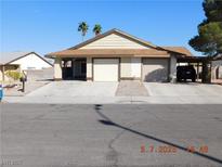 Charming single-story home with a spacious driveway and two-car garage, surrounded by lush palm trees at 4382 Pinegrove St, Las Vegas, NV 89147