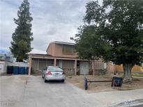 Inviting two-story home with mature trees and a long driveway on a partially cloudy day at 5417 Seabaugh Ave, Las Vegas, NV 89107
