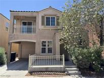 Two-story home featuring a balcony, covered parking, and well-maintained landscaping at 7469 Margollini St, Las Vegas, NV 89148