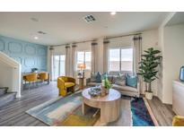 Bright living room features large windows, modern furnishings, and stylish decor with a blue accent wall at 7925 Pandora Sky St # 392, Las Vegas, NV 89084
