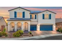 Charming two-story home with blue shutters, a tile roof, desert landscaping, and a two-car garage at 8925 Kenzie Cove St, Las Vegas, NV 89131