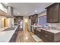 Modern kitchen with stainless steel appliances, wood floors, and large pantry at 8932 Beach Front Dr, Las Vegas, NV 89117