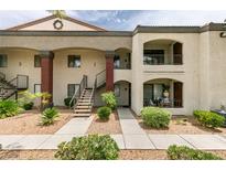 A two-story exterior featuring stucco, brown accents, a small patio, and rock landscaping at 950 Seven Hills Dr # 524, Henderson, NV 89052