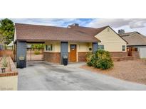 Charming single-story home featuring a gated driveway and neatly landscaped front yard at 1017 E Oakey Blvd, Las Vegas, NV 89104