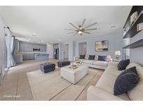 Spacious living room featuring comfortable white sofas, a ceiling fan, and stylish decor at 10373 Northern Hills Ave, Las Vegas, NV 89166