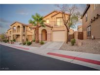 Inviting tan two-story home with landscaped front, complemented by a private balcony above the garage at 1136 Paradise Garden Dr, Henderson, NV 89002