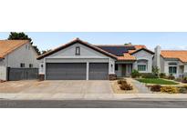 Charming single-story home featuring a two-car garage, tiled roof, desert landscaping, and solar panels at 209 Tamarack Dr, Henderson, NV 89002