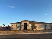 Inviting single-story home with stone accents, desert landscaping, and a three-car garage at 211 E Kimberly Dr, Henderson, NV 89015