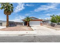 Charming single-story home featuring desert landscaping, an attached garage, and mature palm trees at 2116 Cameron St, Las Vegas, NV 89102