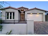 Charming single-story home with a well-manicured front yard, brick driveway, and two-car garage at 2194 Pigeon Hawk St, Las Vegas, NV 89138