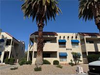 Two-story apartment building with a desert landscape and charming blue awnings at 5012 Newport Cove Dr # C, Las Vegas, NV 89119