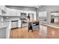 Modern kitchen features white cabinets, stainless steel appliances, and a wood-topped island with wine rack at 5012 Newport Cove Dr # C, Las Vegas, NV 89119