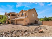 Spacious two-story home featuring a three-car garage and charming stucco exterior at 5872 Revital Ct, Las Vegas, NV 89131