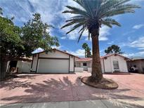 Charming single-story home with a Spanish tile roof, two-car garage and mature trees at 6191 Bullion Blvd, Las Vegas, NV 89103