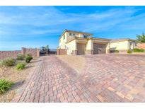 Two-story stucco home with a two-car garage and brick driveway and gated RV parking at 6311 Baker Creek St, Las Vegas, NV 89149