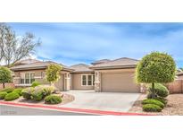 Charming single-story home showcasing manicured landscaping and a spacious driveway leading to a two-car garage at 7332 Redhead Dr, North Las Vegas, NV 89084
