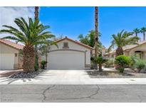 Charming single-story home featuring a well-maintained yard with palm trees and a spacious two-car garage at 7865 March Brown Ave, Las Vegas, NV 89149